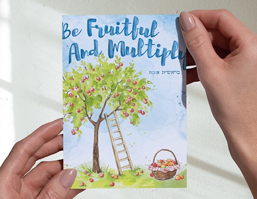 Hands holding a card with an apple tree, ladder, basket of apples, and text: "Be Fruitful and Multiply.