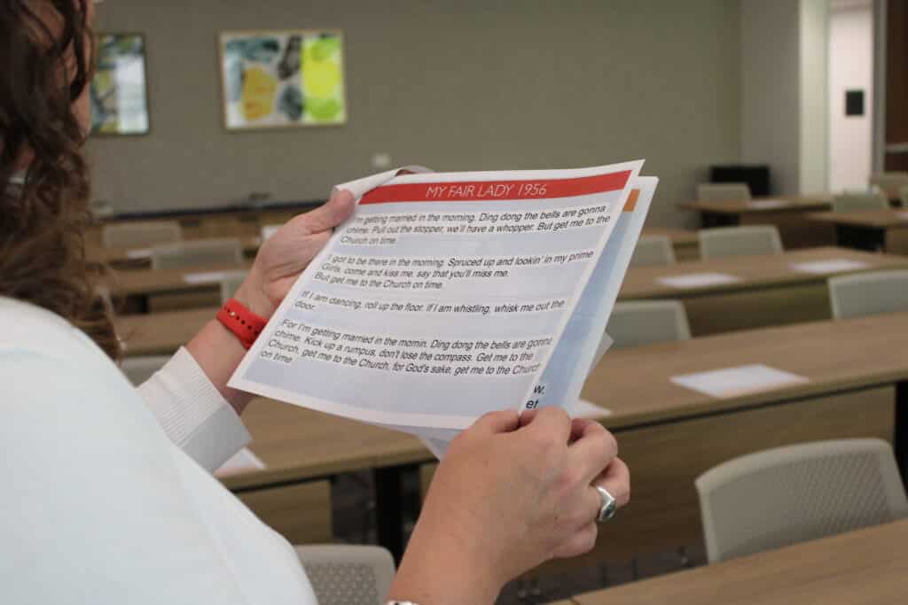 A participant holds a printed songbook with lyrics used during the sing-along portion of the Holocaust Survivor Day program.