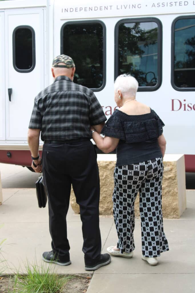 A Holocaust survivor walks arm in arm with her son toward a senior living community shuttle outside the JFS Dallas building after the event.