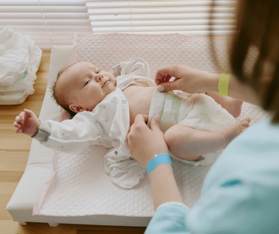 Image of a smiling baby receiving a diaper change 