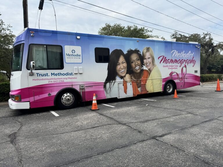 Methodist Mammography mobile clinic parked in a lot, featuring smiling women and contact information on its side.
